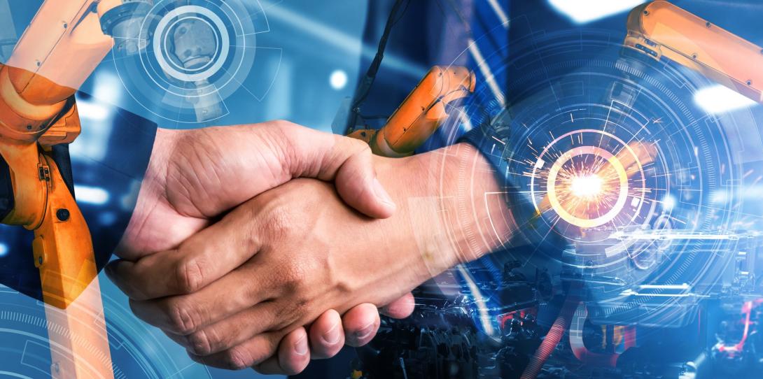 A handshake between two men in business suits, surrounded by semi-transparent images of manufacturing equipment.